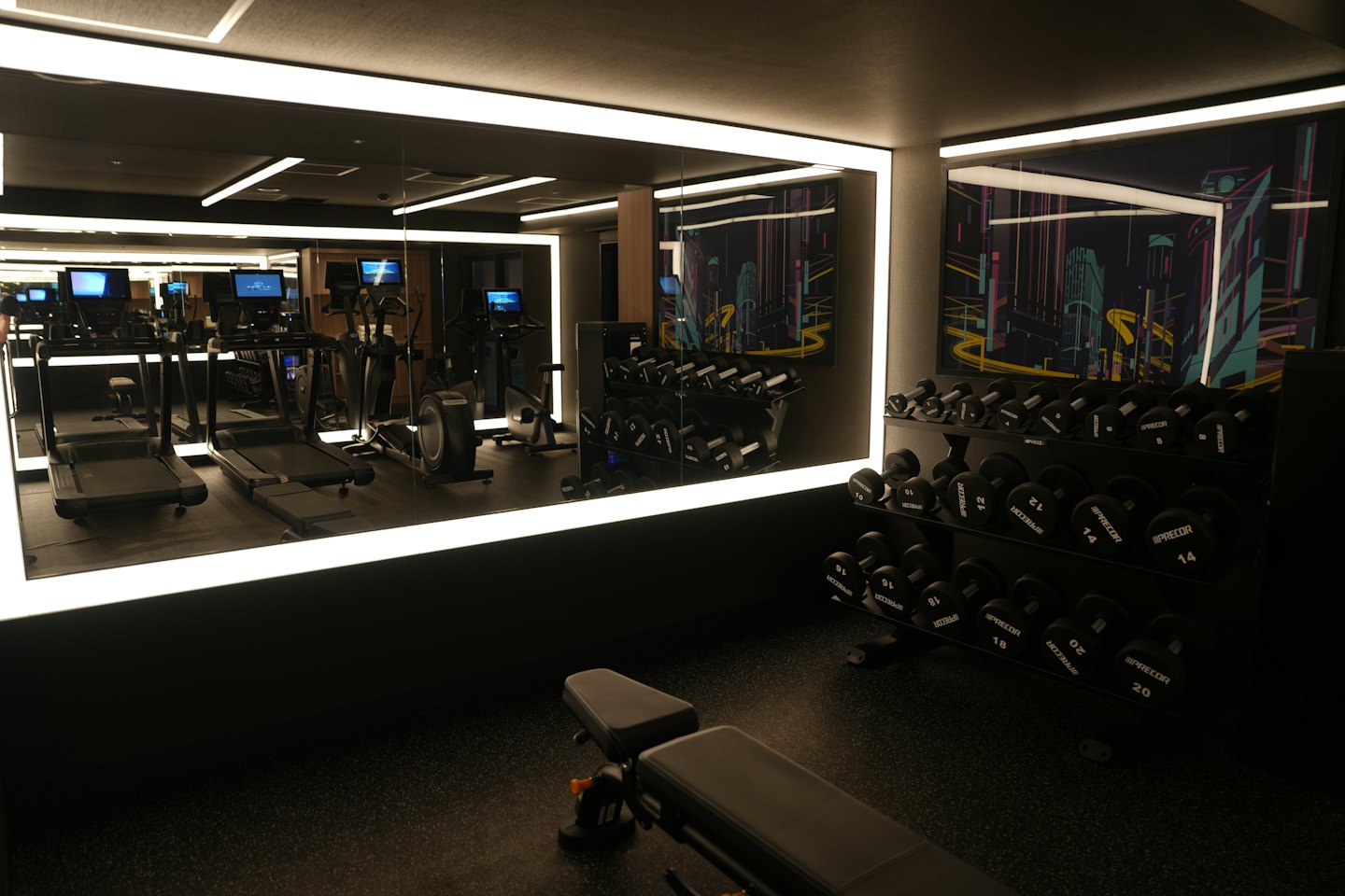 Koşu bantları ve dambıllarla modern spor salonu içi.